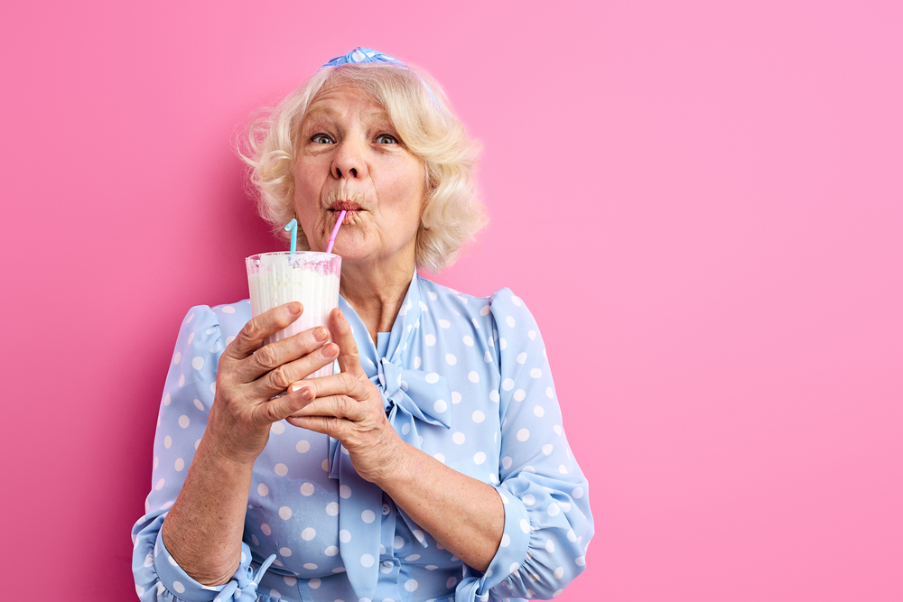donna anziana beve latte con cannuccia