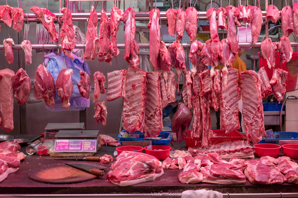 Carne appesa sul banco di un mercato; wet market