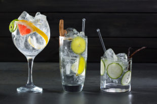 Tre cocktail a base di gin con ghiaccio e pompelmo (a sinistra), lime e cannella (al centro), cetriolo (a destra)