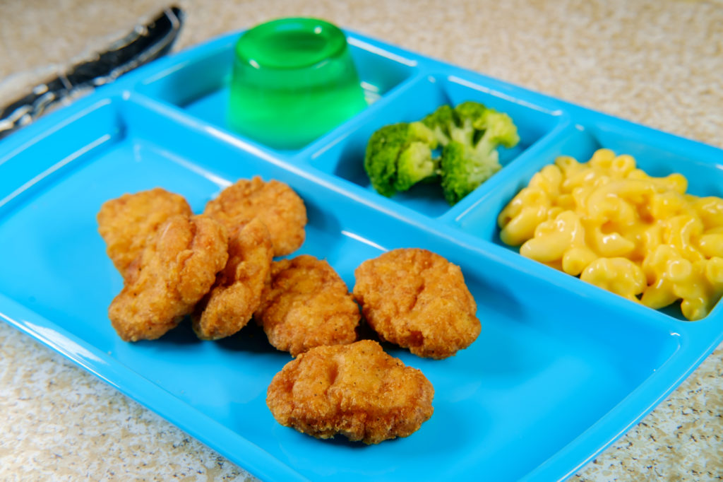 Vassoio di mensa scolastica con nugget, maccheroni al formaggio, broccoli e gelatina