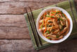 Piatto di chow mein noodles su tovaglietta con bacchette