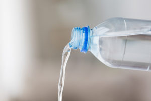 acqua versata da bottiglia di plastica trasparente