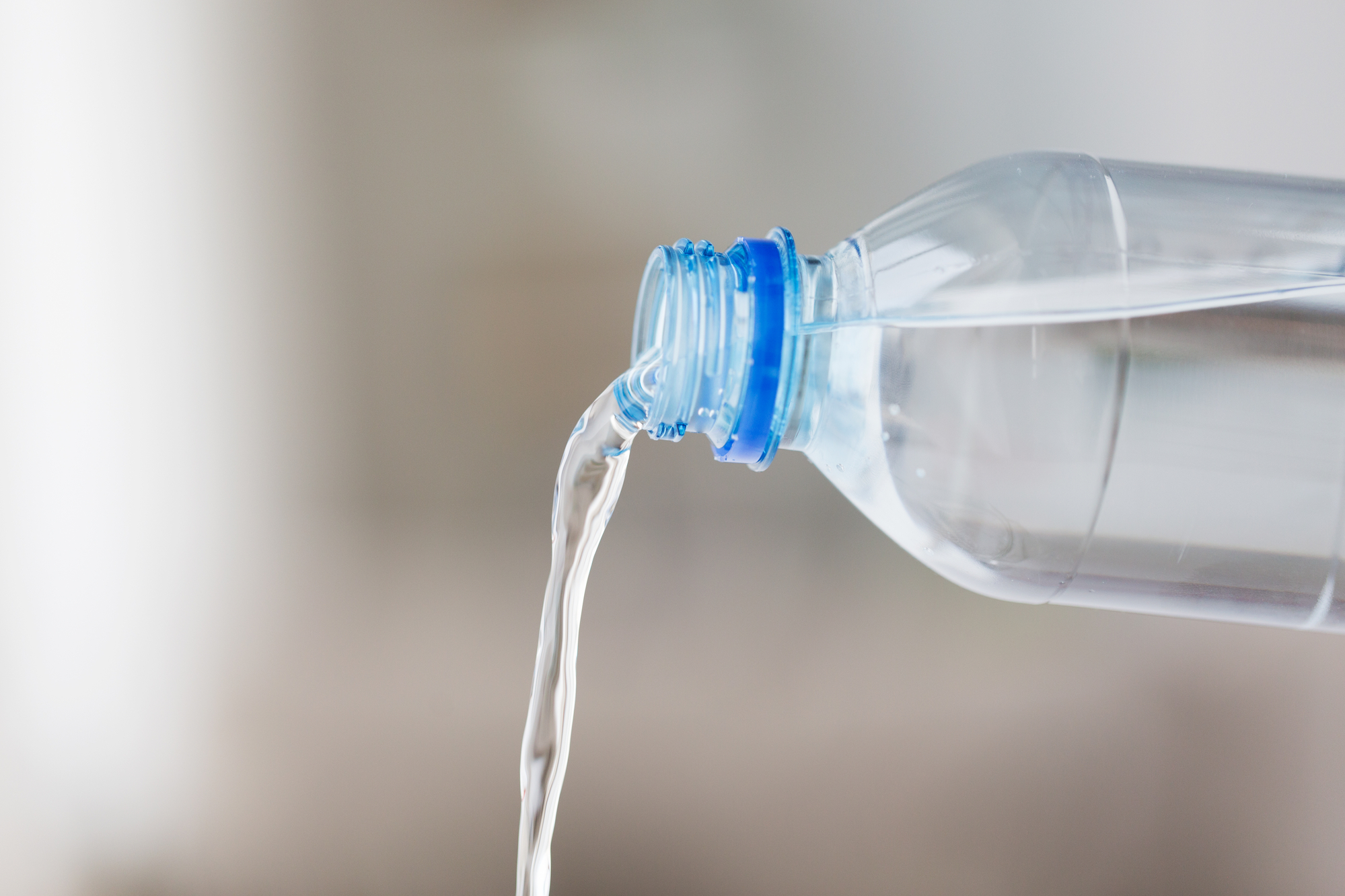 acqua versata da bottiglia di plastica trasparente