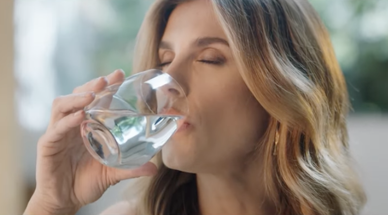 Elisabetta Canalis beve acqua da un bicchiere di vetro trasparente. Pubblicita San Benedetto