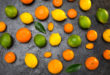 Agrumi misti su sfondo scuro: arance, limoni, lime, mandarini o clementine, kumquat