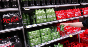 Confezioni multiple di Coca-Cola sugli scaffali di un supermercato