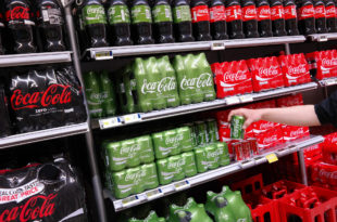 Confezioni multiple di Coca-Cola sugli scaffali di un supermercato
