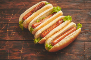 Hot dog con wurstel e insalata; concept: junk food, alimenti ultraprocessati