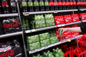 Confezioni di Coca-Cola Classica, Zero e Life in bottiglia e lattina sugli scaffali di un supermercato