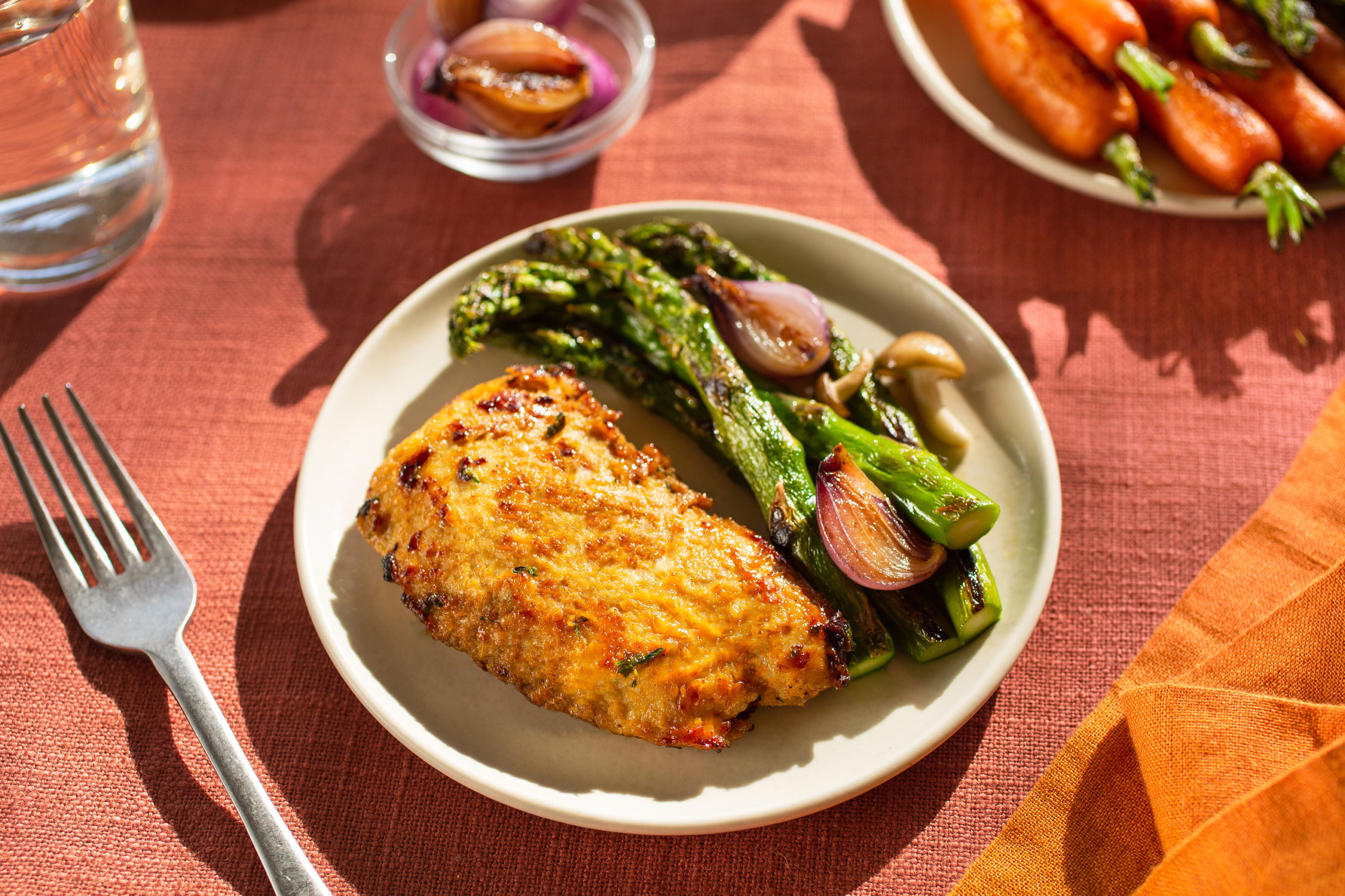 piatto con carne coltivata di pollo con asparagi e scalogno