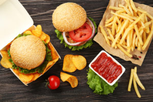 Gustoso hamburger con patatine fritte e patatine sul tavolo; concept: junk food, fast food
