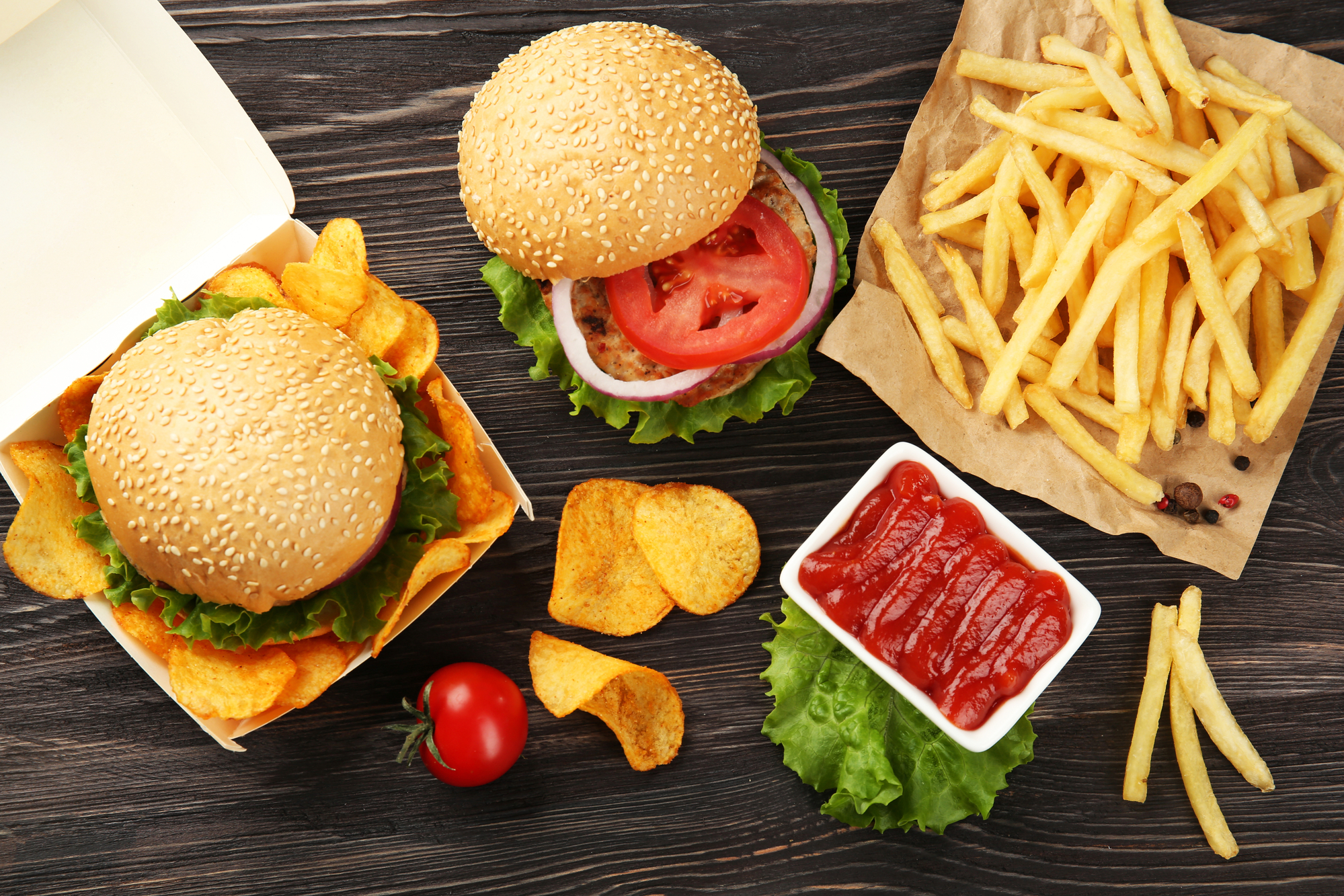 Gustoso hamburger con patatine fritte e patatine sul tavolo; concept: junk food, fast food