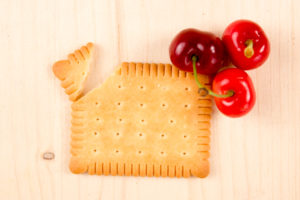 Rosso ciliegie su uno sfondo di legno con biscotto al burro petit zuccheri frutta