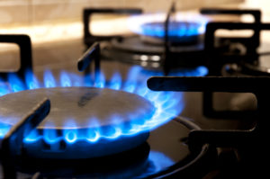 fornelli a gas neri e due fiamme ardenti da vicino cucina