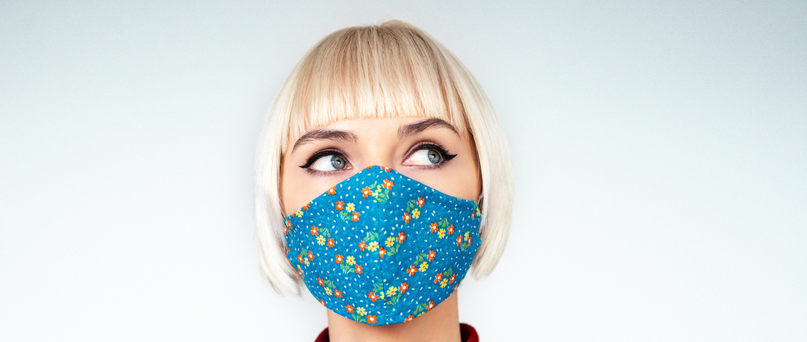 Donna pensosa e premurosa che indossa una maschera facciale fatta a mano durante la quarantena dell'epidemia di infezione da coronavirus.