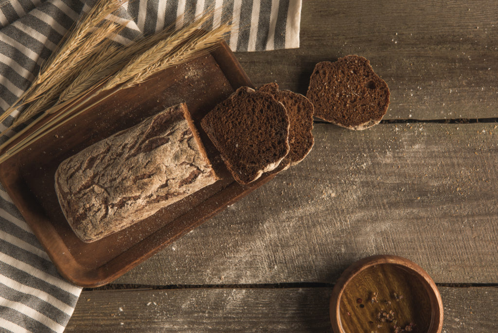Pane integrale di segale su un tavolo di legno con spighe