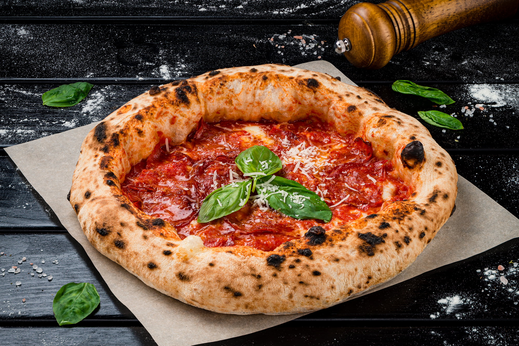 pizza napoletana fatta in casa alla carbonara dal forno con pancetta, prosciutto, formaggio, salame, parmigiano e basilico