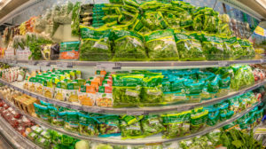 Banco frigo di un supermercato con insalate in busta