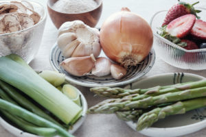 Assortimento di alimenti prebiotici: cipolla, aglio, porri, asparagi, crusca, fragole