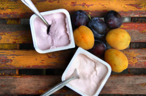 Yogurt sul tavolo di legno e mix di frutta