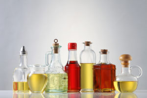 Assortimento di oli vegetali in bottiglie di vetro: olio di oliva, olio di palma, olio di girasole, olio di colza, olio di arachidi, olio di semi