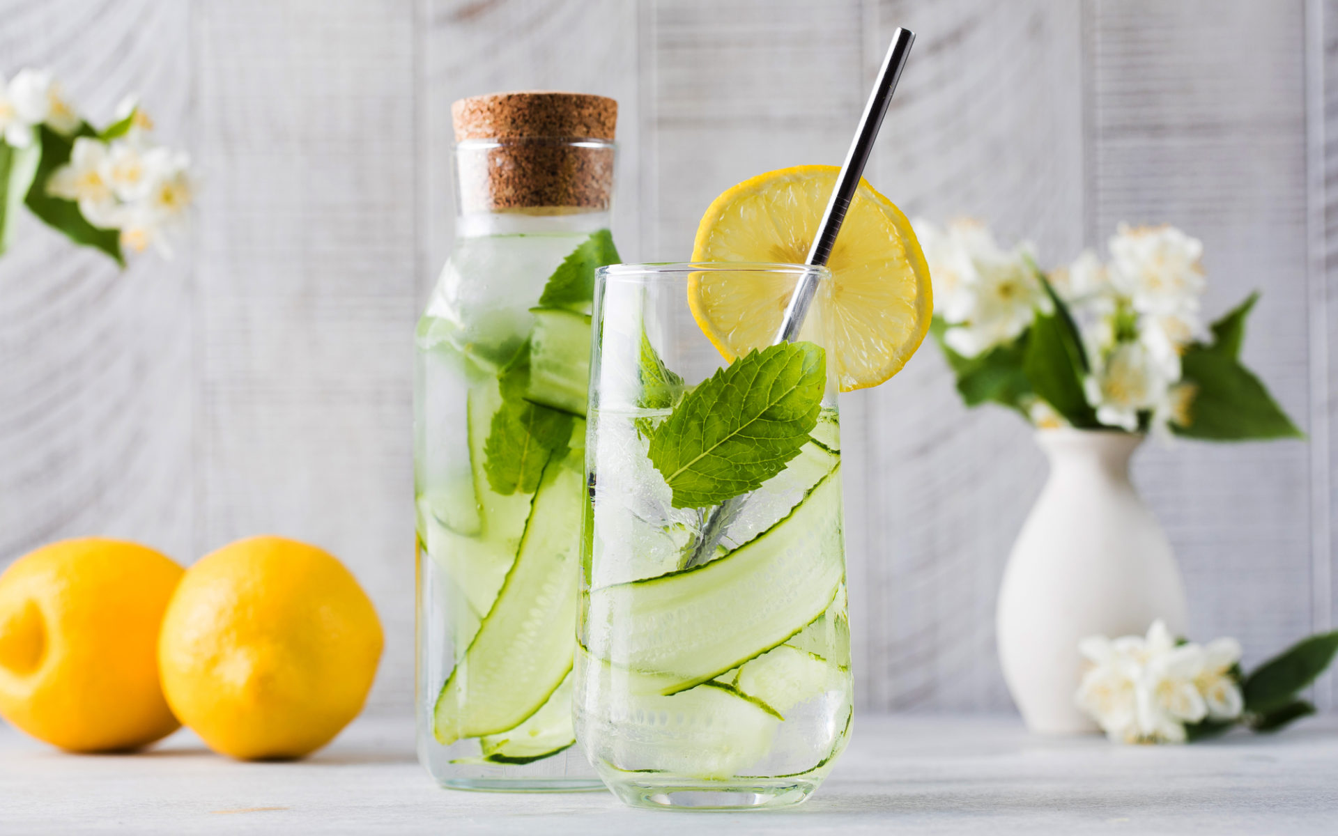 Acqua aromatizzata con cetriolo, menta e limone in una bottiglia e un bicchiere