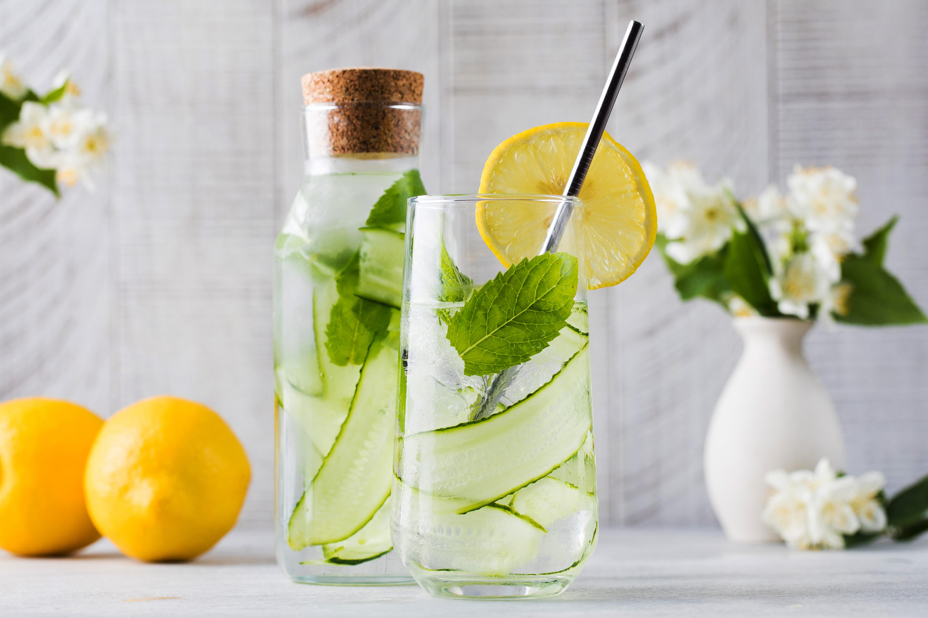 Acqua aromatizzata con cetriolo, menta e limone in una bottiglia e un bicchiere