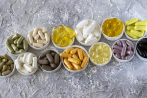 Farmaci multipli. ordinati in piccoli piatti o coperchi dalle gemme su uno sfondo grigio. Farmaci e pillole popolari. integratori pastiglie pillole capsule