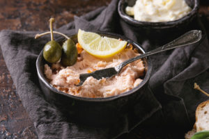 Paté o salsa al salmone con capperi e limone in una ciotola nera