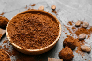 Ciotola di cacao in polvere accanto a tartufi al cioccolato e fave di cacao