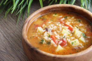 Zuppa con cereali e verdure in una ciotola di terracotta