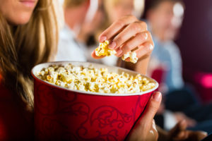 Donna mangia popcorn al cinema