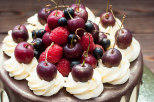 Torta con panna montata ciliegie, lamponi e mirtilli