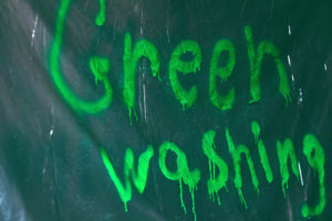 Graffiti Graffiti Greenwashing spruzzati con vernice verde su politene. Marketing ingannevole di un prodotto, di un servizio o di un'azienda ecologica, di un marchio. Foto di alta qualità greenwashing claim etichette ambiente