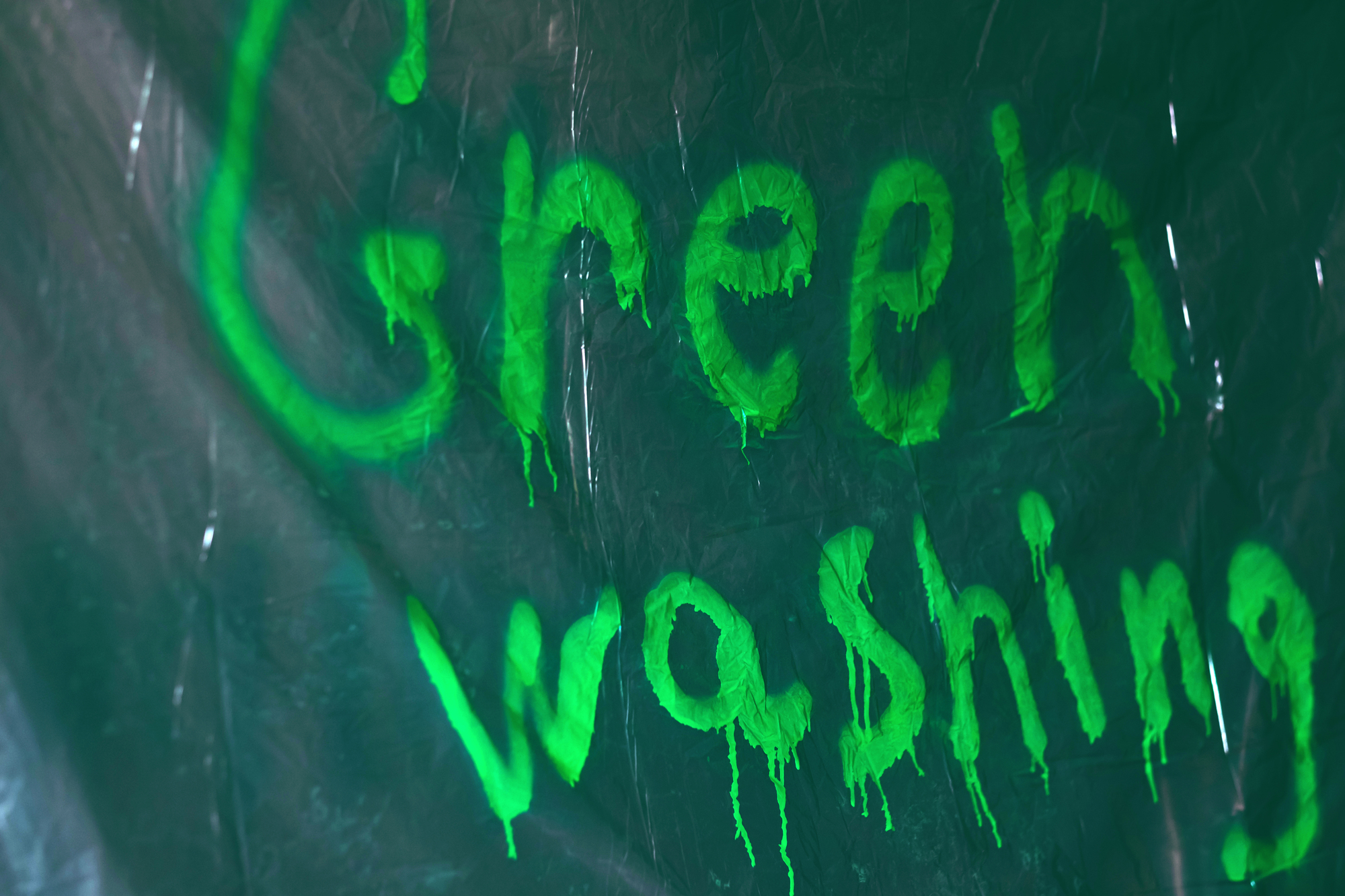 Graffiti Graffiti Greenwashing spruzzati con vernice verde su politene. Marketing ingannevole di un prodotto, di un servizio o di un'azienda ecologica, di un marchio. Foto di alta qualità greenwashing claim etichette ambiente