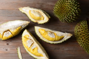 Durian intero e sgusciato su un tavolo; concept: frutta esotica