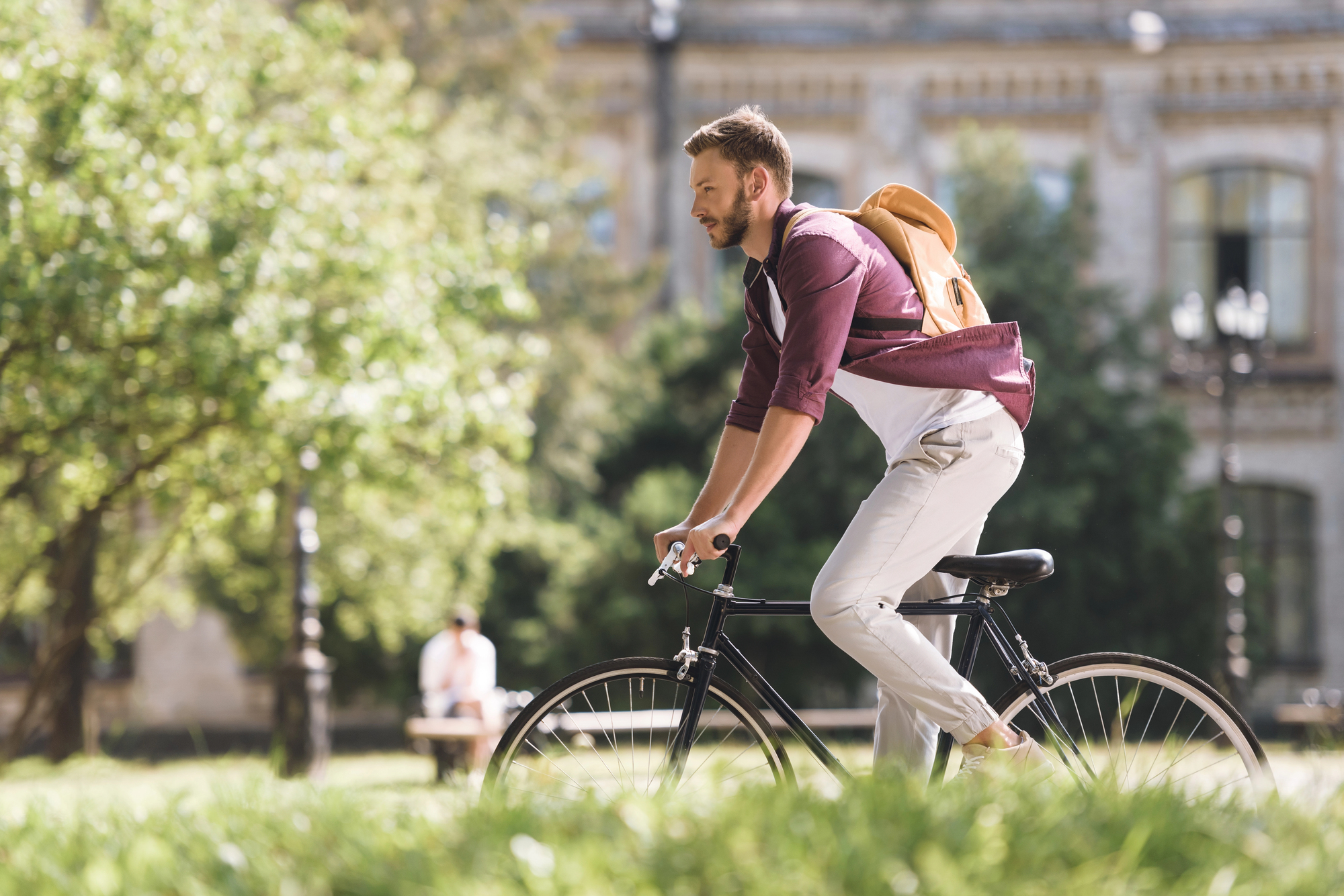 Giovane uomo in bicicletta in un parco cittadino; concept: sport, attività fisica, salute