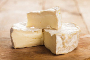 Forma di formaggio tipo Camembert tagliato su un tavolo di legno