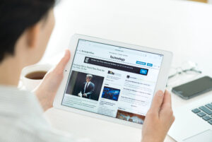 Una persona legge un giornale online su un tablet; concept: media, news, giornalismo, New York Times