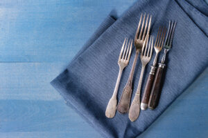 Forchette vintage o antiche su un tovagliolo blu; concept: posate