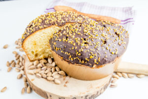 Un panettone farcito di crema al pistacchio ricoperto di cioccolato e granella di pistacchio; concept: Natale