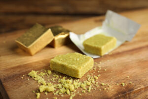 Alcuni dadi da brodo incartati e scartati su un tagliere di legno