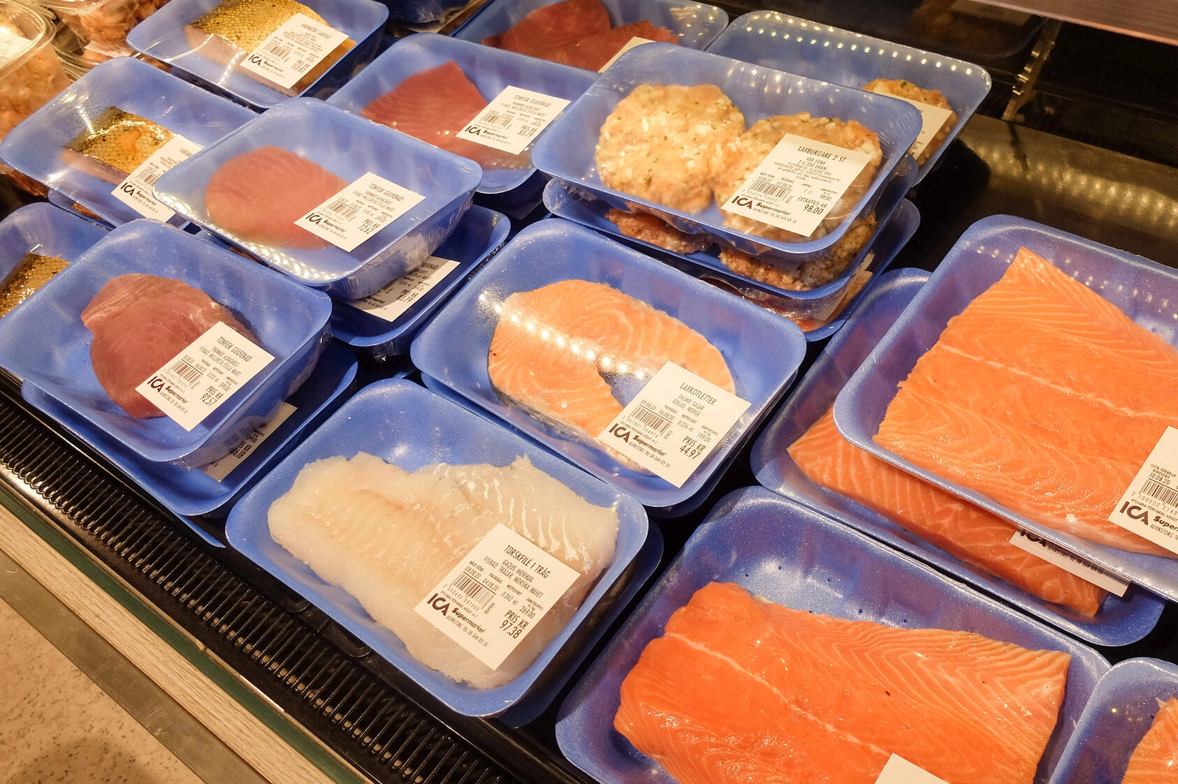 Vaschette di pesce fresco nel banco pescheria di un supermercato