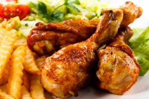 Cosce di pollo arrosto o alla griglia con patatine e insalta