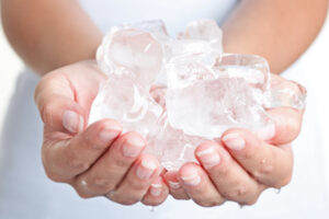 Una donna tiene tra le mani cubetti di ghiaccio