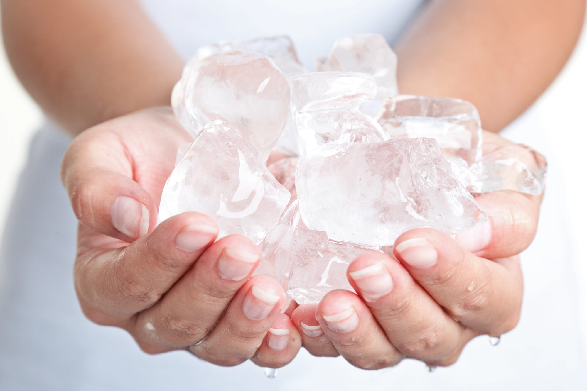 Una donna tiene tra le mani cubetti di ghiaccio