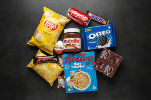 Alcuni prodotti di Ferrero, Coca-Cola, PepsiCo, Danone, Kellogg's, Mars: Nutella, Kinder Sorpresa, Lay's, Danette, Oreo; Concept: Big Food, junk food ultra processati