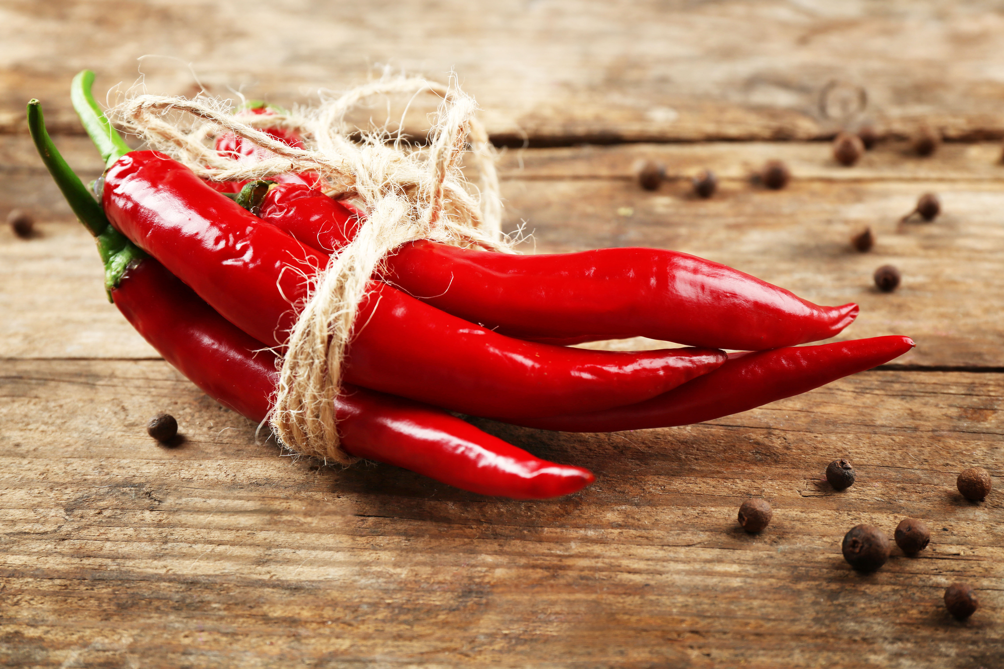 Primo piano di peperoncini piccanti rossi con spezie su un tavolo di legno piccante peperoncino