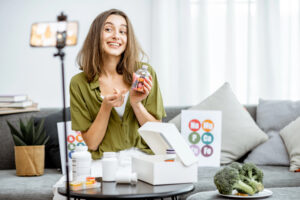 Un'influencer registra un contenuto per i social media presentando degli integratori