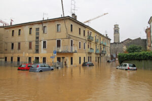 auto nelle strade e sulle vie sommerse dal fango dell'alluvione causata dallo straripamento del fiume crisi climatica cambiamento climatico alluvione allagamento meteo pioggia